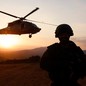 An Israeli soldier looks on as a military helicopter hovers.