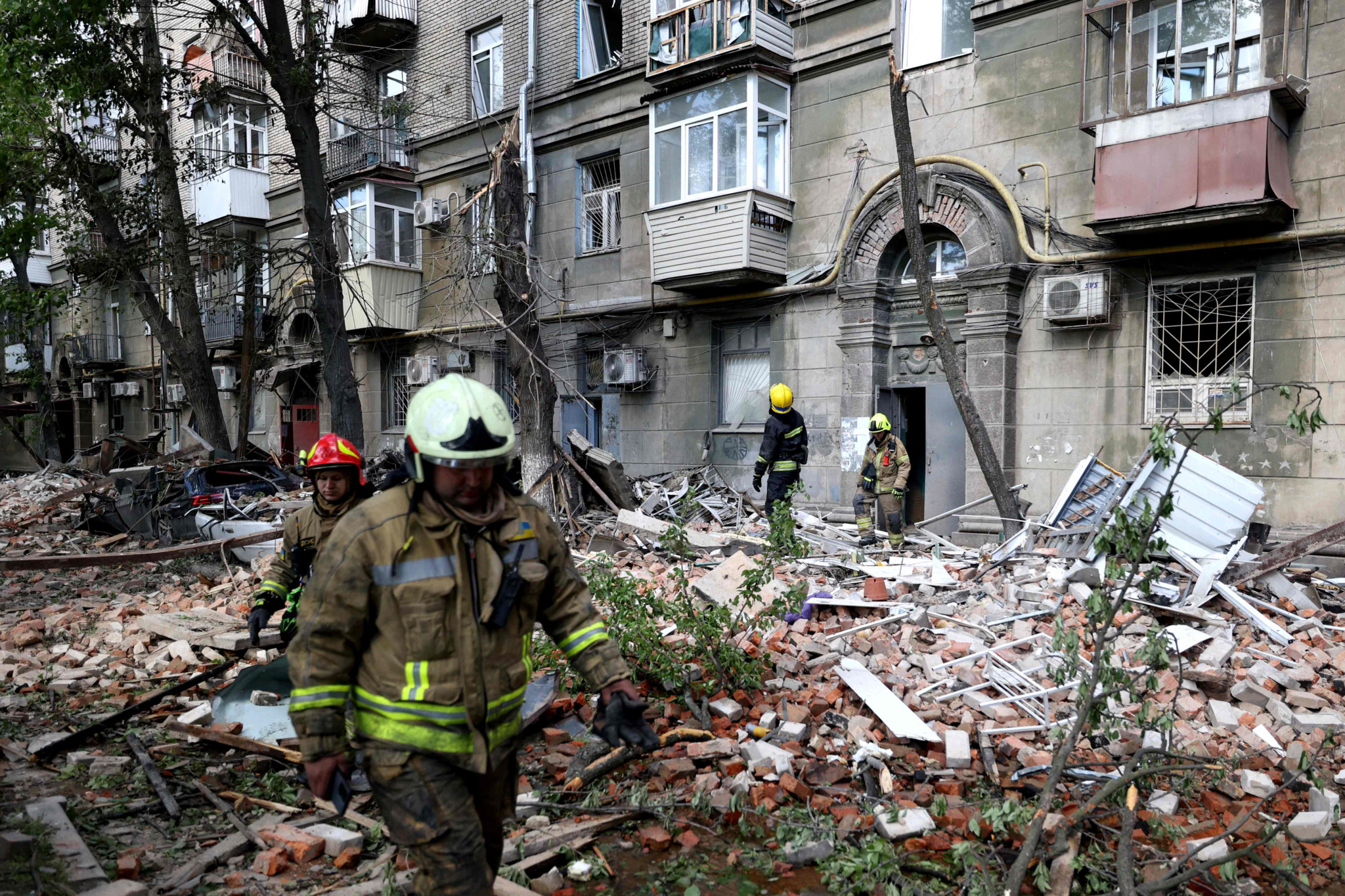 TOPSHOT - Ukrainian rescuers work in the courtyard of a residential building damaged as a result of a missile attack in Dnipro on April 19, 2024, amid the Russian invasion of Ukraine. Russian strikes against Ukraine on April 19, 2024 killed at least eight people, including two children, as Kyiv said it shot down a Russian strategic bomber for the first time. (Photo by Anatolii Stepanov / AFP)