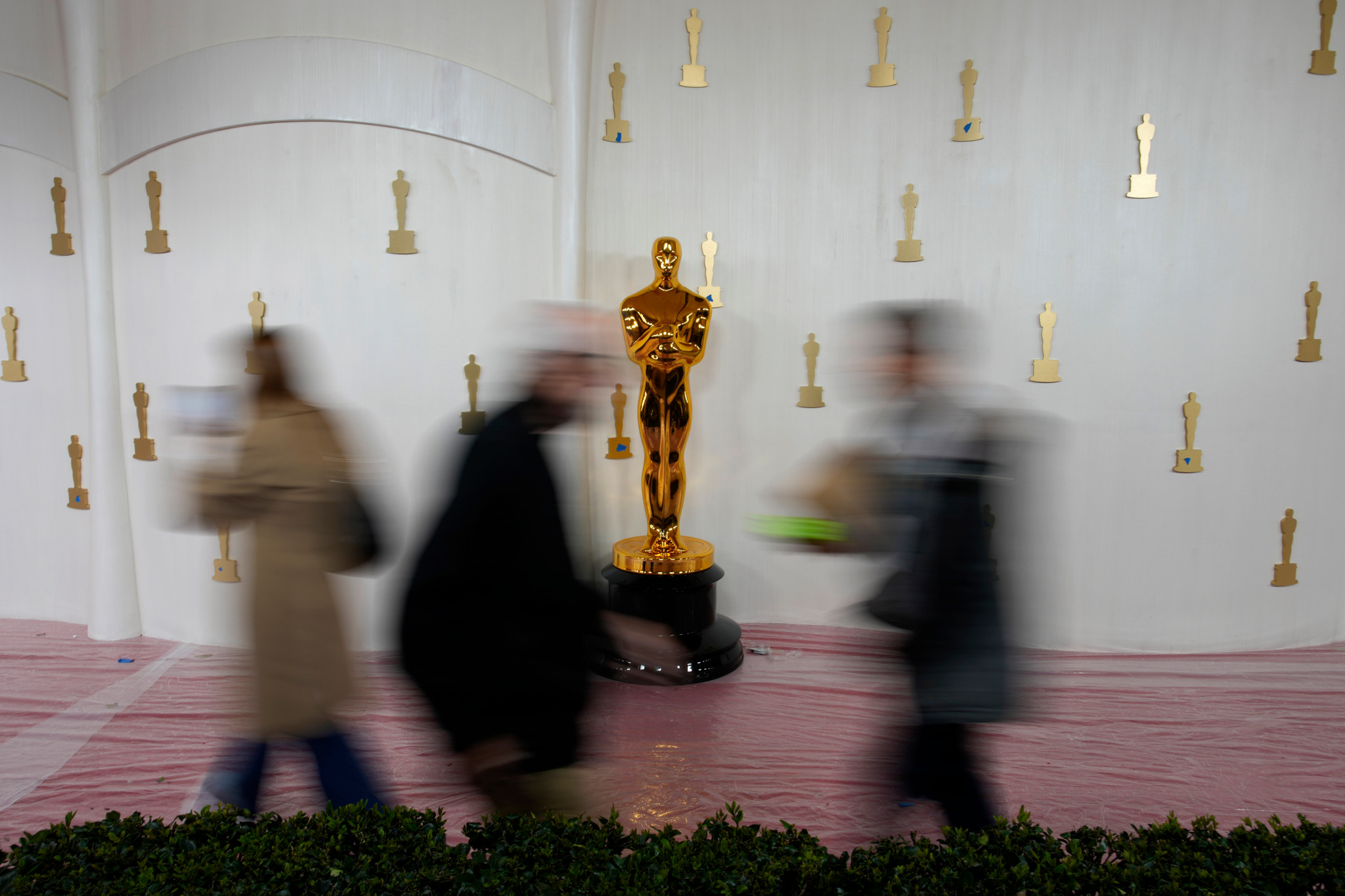 People walk by an Oscars statue on the red carpet ahead of the 96th Academy Awards, Thursday, March 7, 2024, in Los Angeles, Calif. (AP Photo/John Locher)