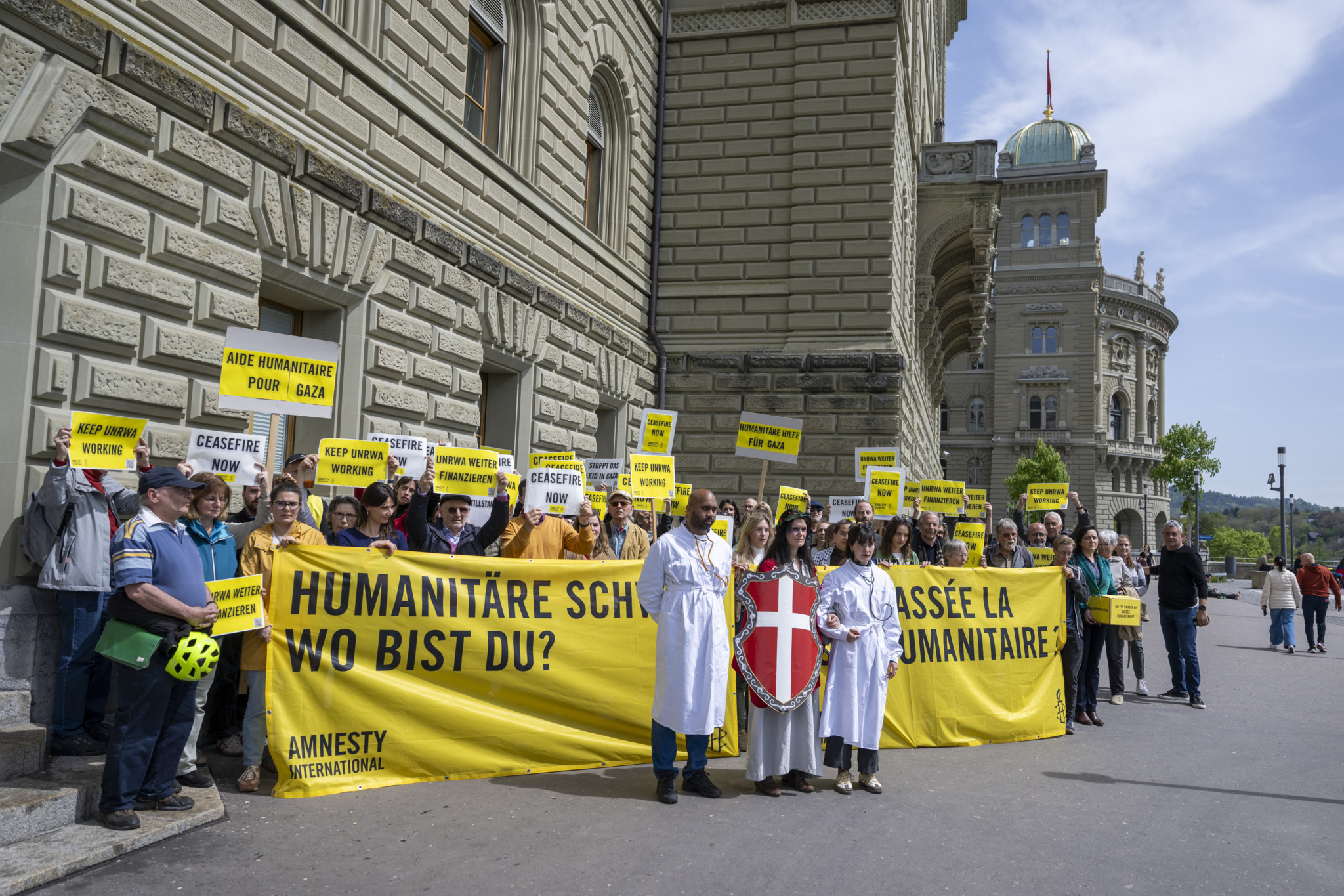 Personen von Amnesty International und weiteren Organisationen reichen die Petition Humanitaere Schweiz wo bist du ein, am Montag, 29. April 2024, in Bern. Sie fordern mit den .45?000 Unterschriften einen Waffenstillstand und Uno-Hilfe in Gaza. (KEYSTONE/Peter Schneider)