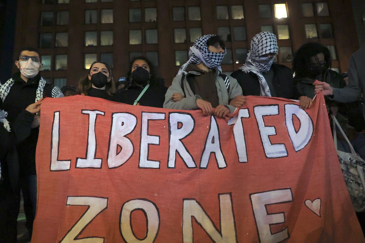 Pro-Palestinian protesters holding a sign that says “Liberated Zone” in New York.