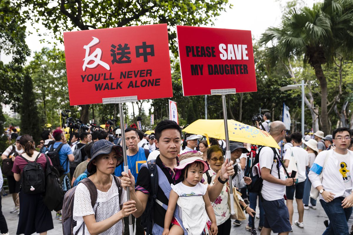 Hong Kong protesters with child and signs. 