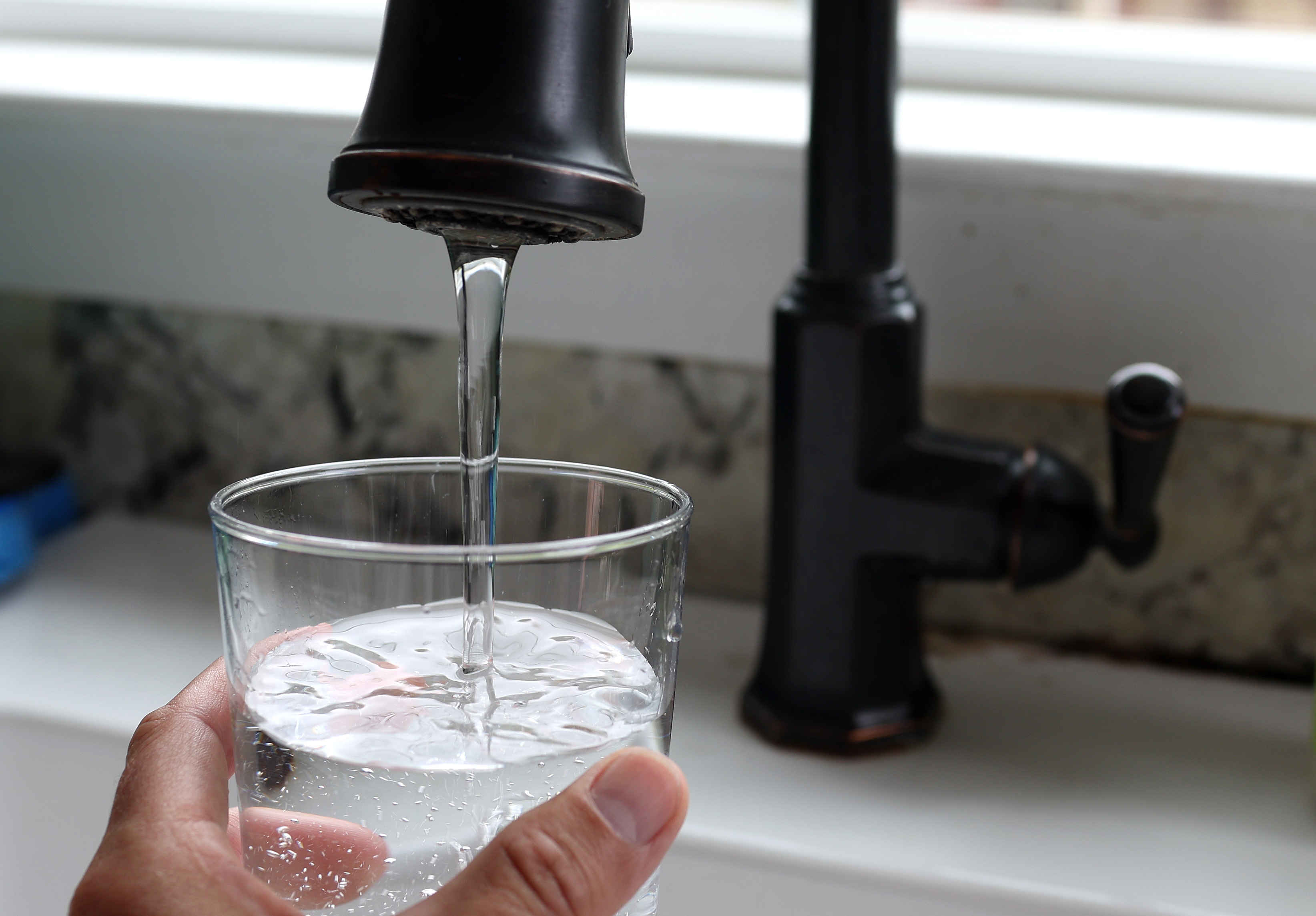 In this photo illustration, water from a tap fills a glass on July 6, 2023, in San Anselmo, California.