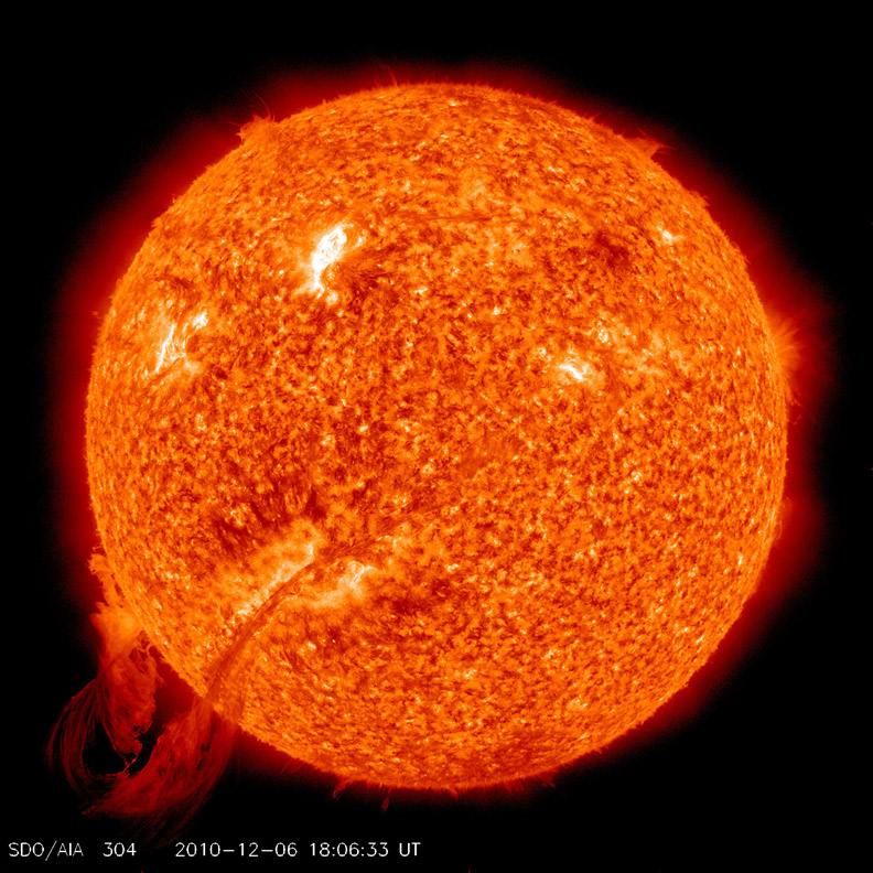 An image of the sun, taken from space and showing coronal ejections along with swirling gases on the star’s surface, all tinted bright orange.
