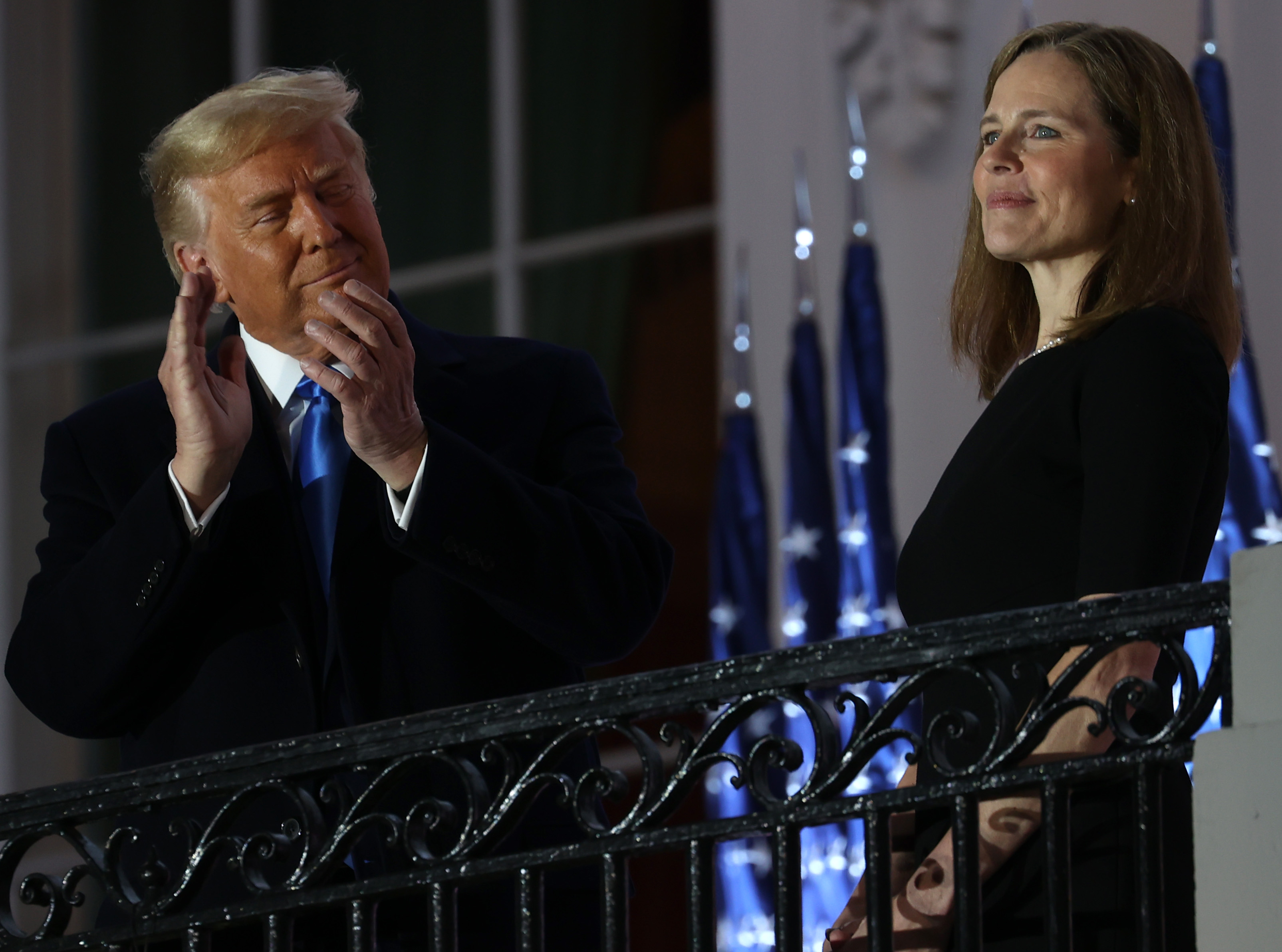 Donald Trump claps as he looks on at Amy Coney Barrett.