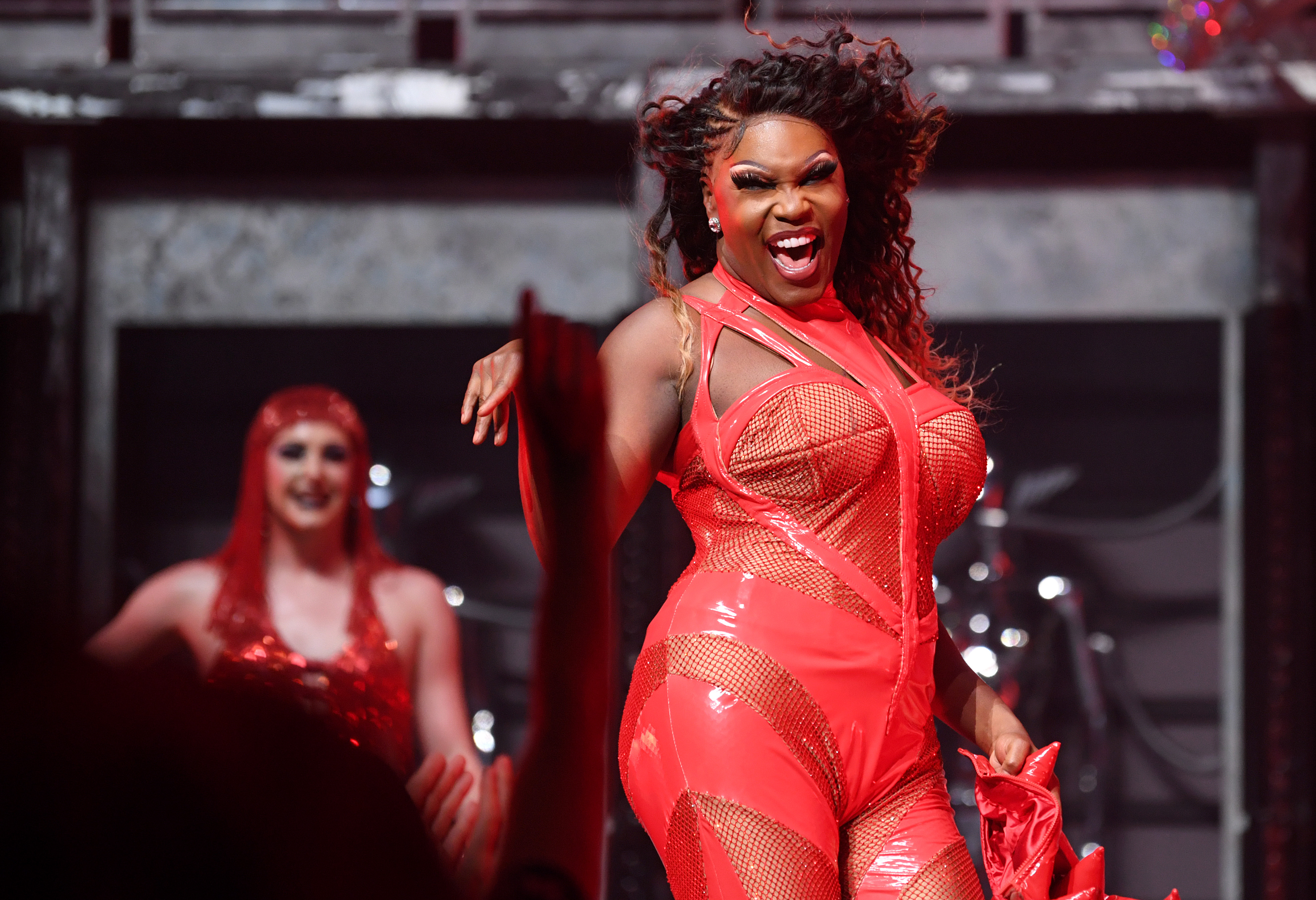 A drag performer smiles and poses during a performance.