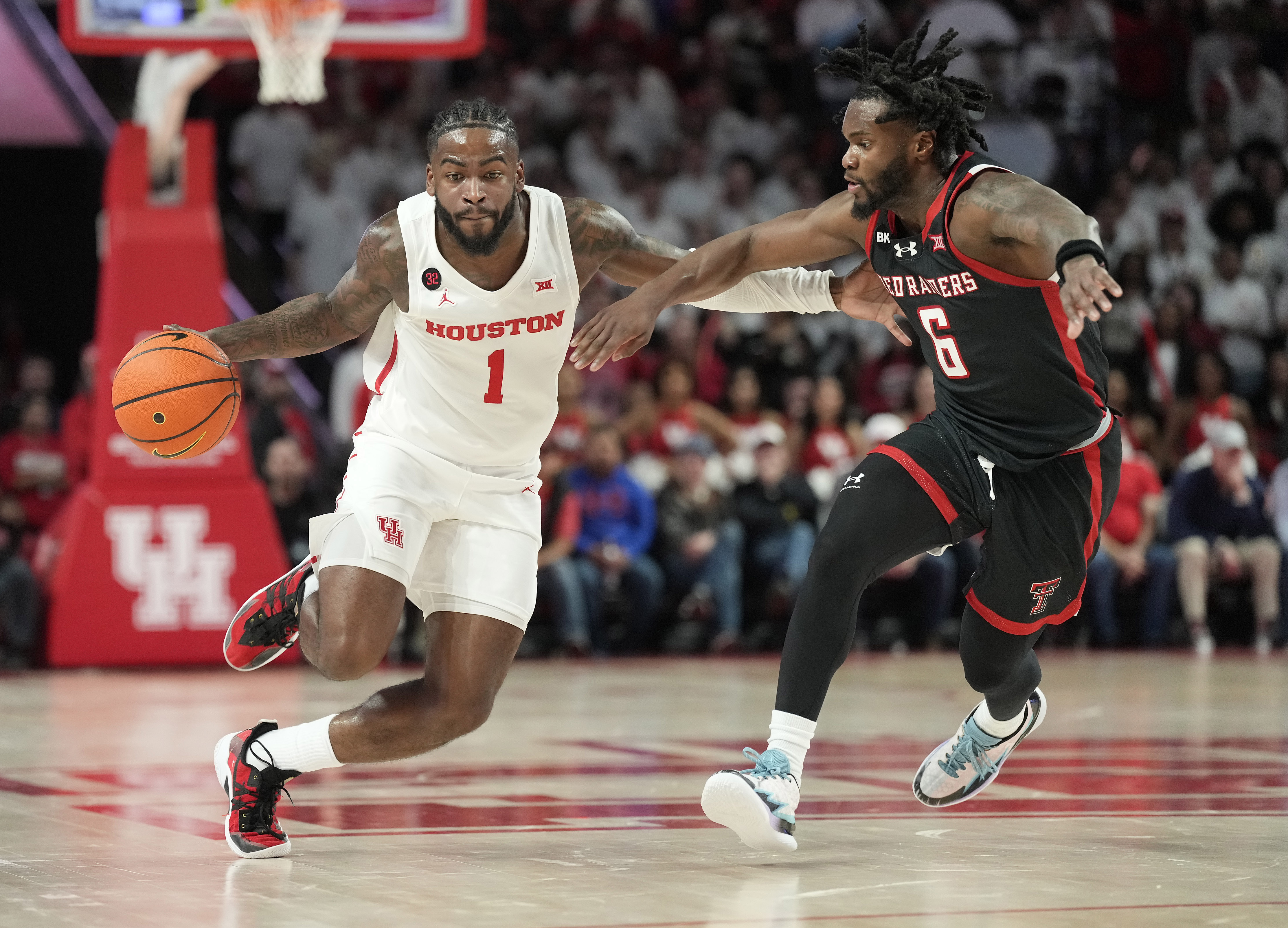 Houston Cougars guard Jamal Shead, wearing the number 1, drives the ball against Texas Tech Red Raiders guard Joe Toussaint, number 6, during the second half of a mens NCAA basketball game at the Fertitta Center on January 17.