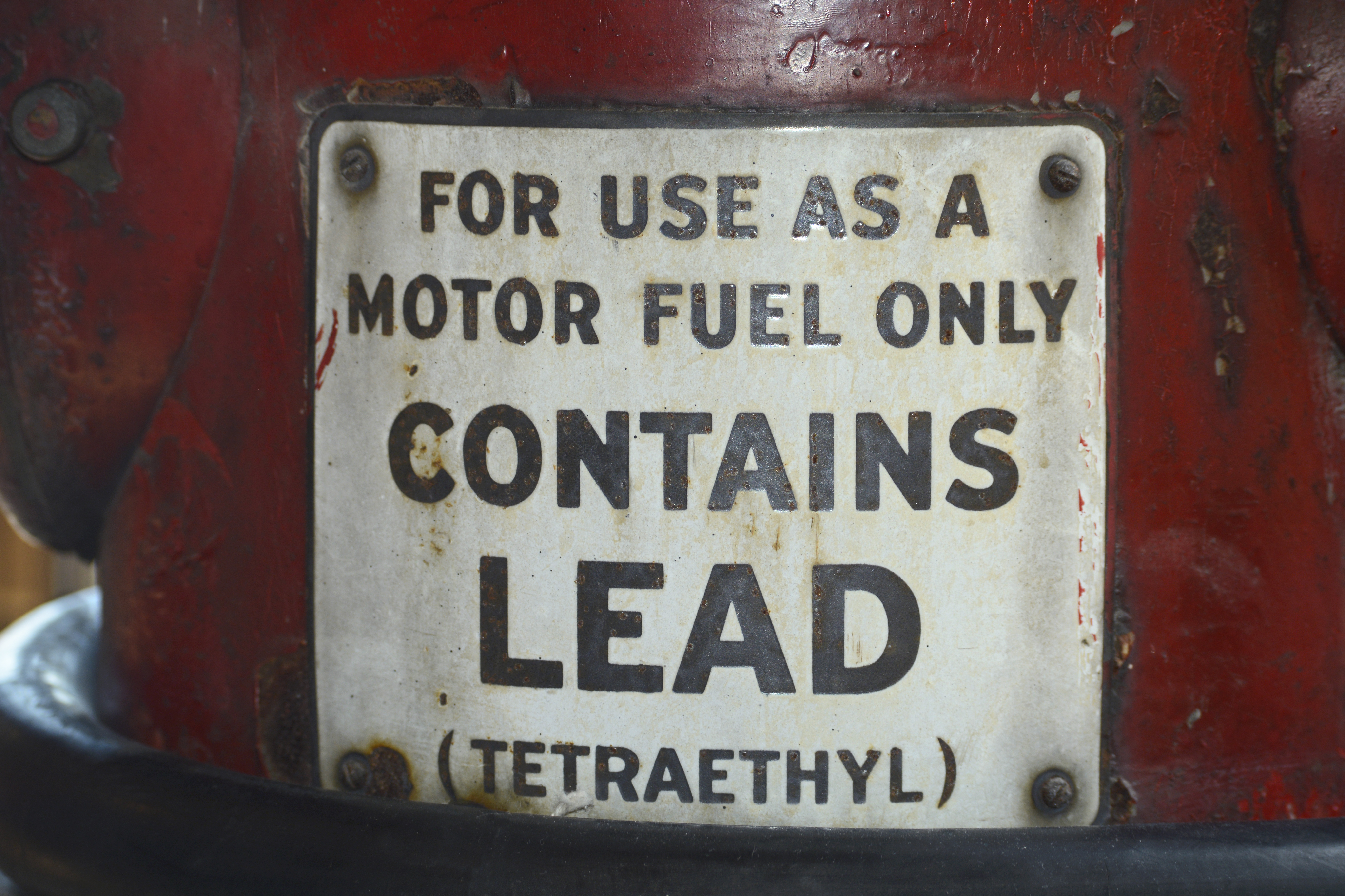 A metal container with a label reading “For use as a motor fuel only. Contains lead (tetraethyl)”