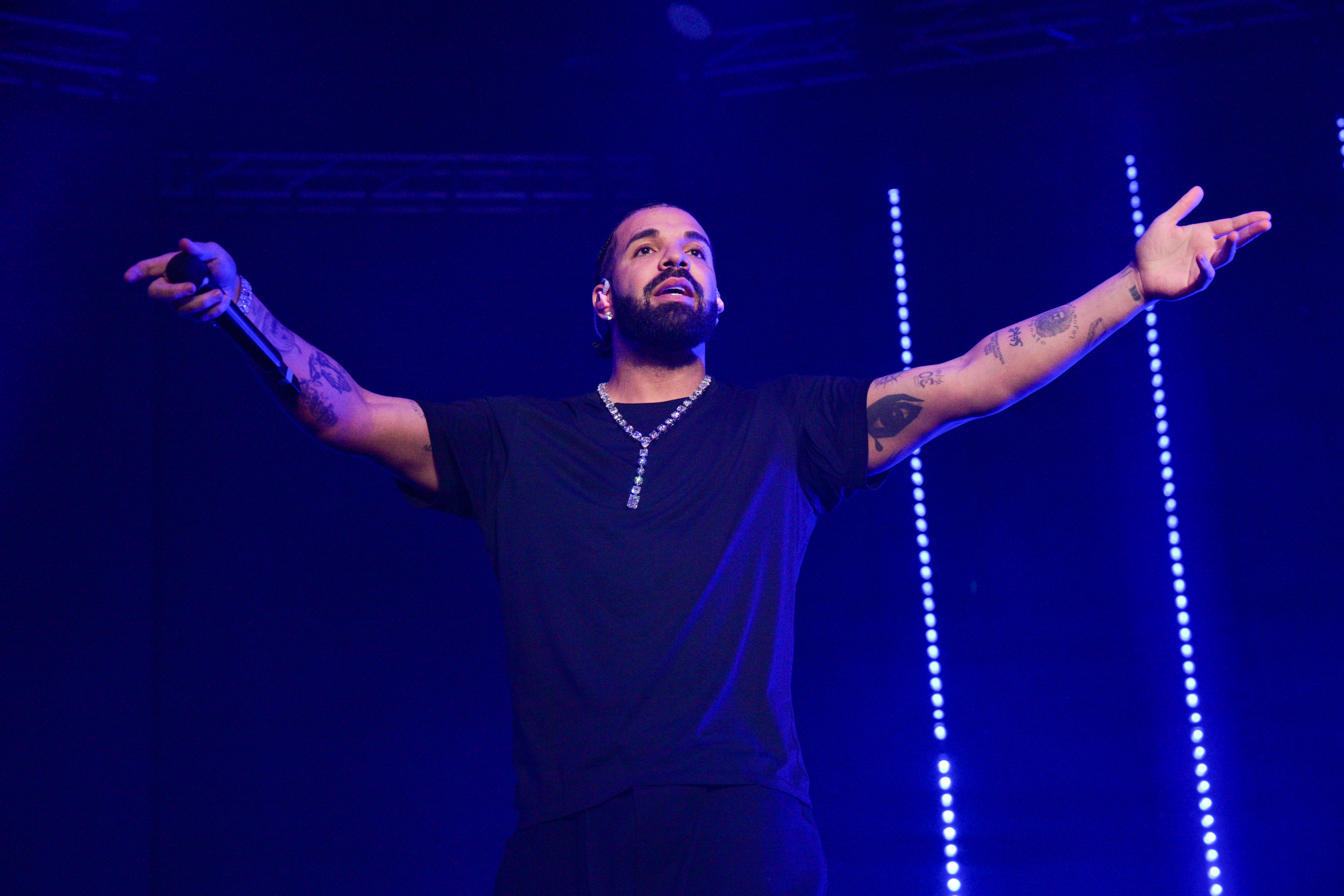 Drake onstage with his arms open wide.