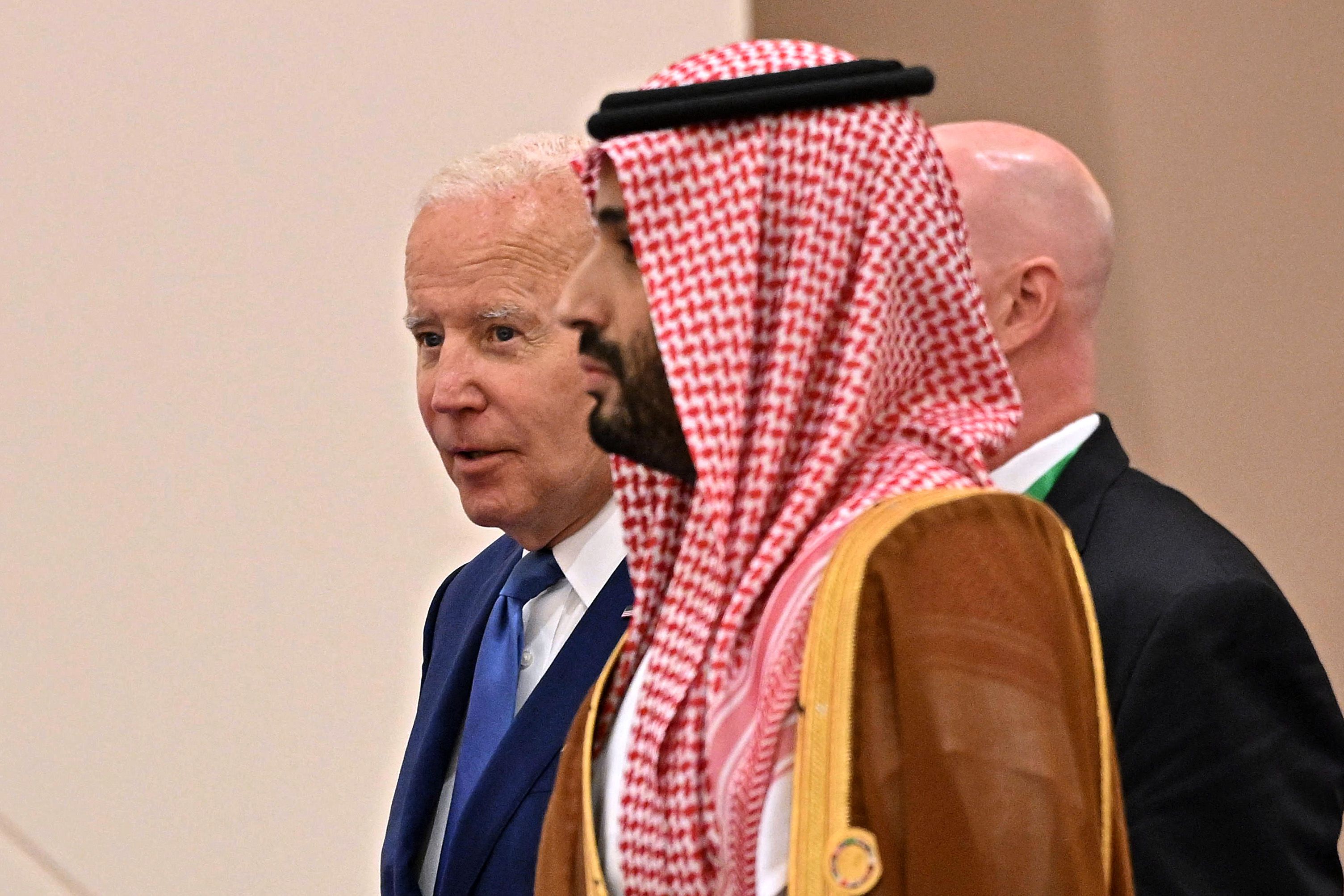 Biden walking behind Crown Prince Mohammed bin Salman as the two enter a room.