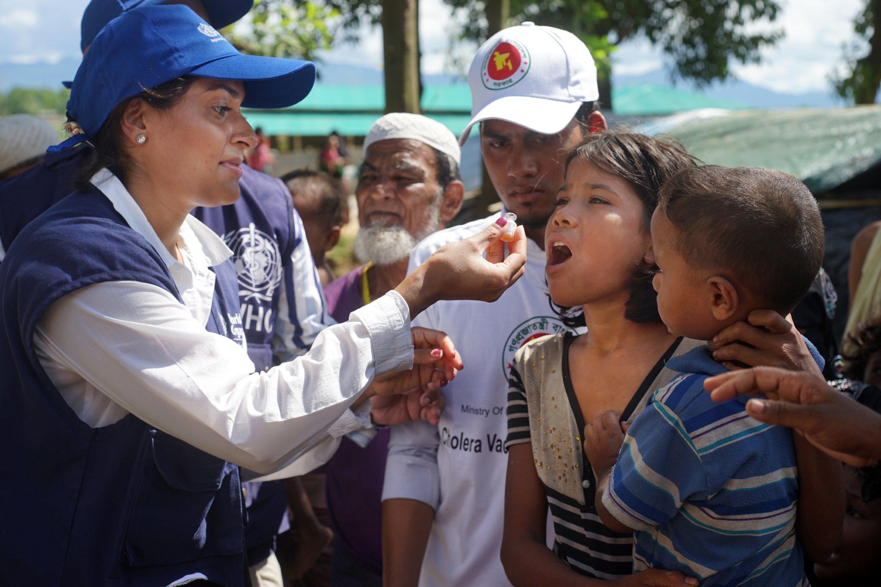 A WHO Officer gives an oral vaccine to a child.