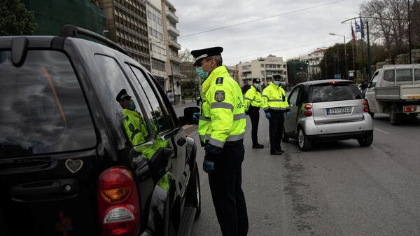 Сотрудники полиции проверяют документы у водителей автомобилей в Афинах
