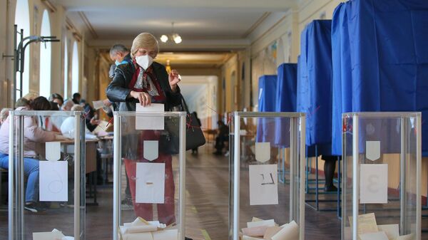 Женщина голосует на одном из избирательных участков в Киеве