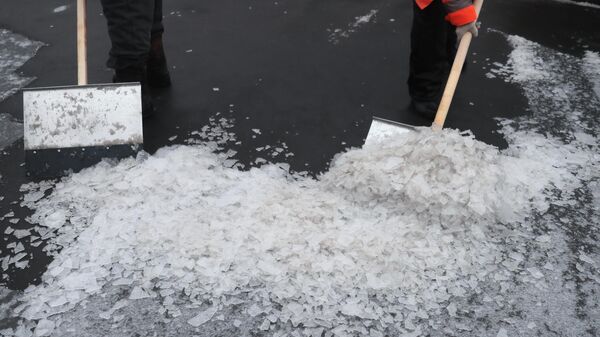 Работники коммунальных служб убирают улицу в Москве после прошедшего ледяного дождя