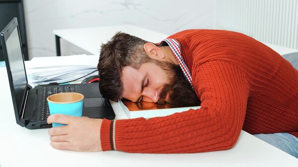 Уставший человек спит в офисе