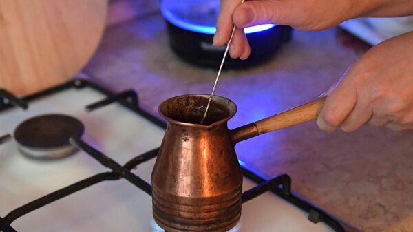 Приготовление кофе в турке на газовой плите. Архивное фото