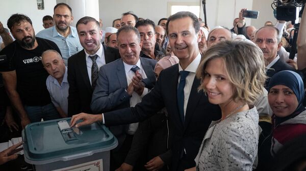 Башар Асад опускает бюллетень в урну во время выборов президента Сирии