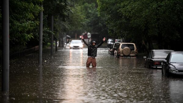 Мужчина одной из улиц в Москве во время дождя
