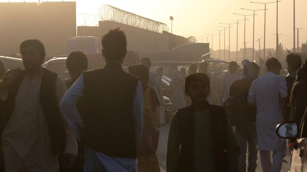 Люди возле пункта эвакуации возле международного аэропорта имени Хамида Карзая в Кабуле