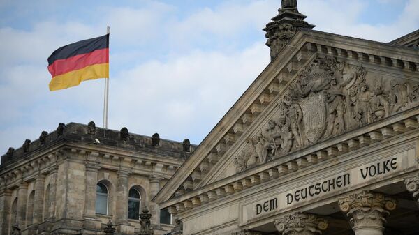 Национальный флаг Федеративной Республики Германия над зданием бундестага в Берлине в день выборов в парламент Германии