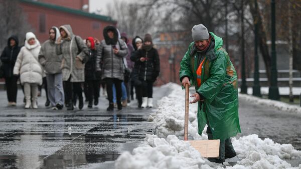Работница коммунальной службы убирает снег в Александровском саду в Москве