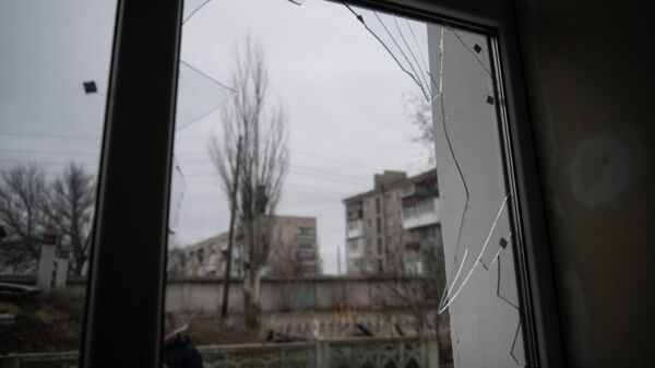 Разбитое в результате обстрела окно в Донбассе