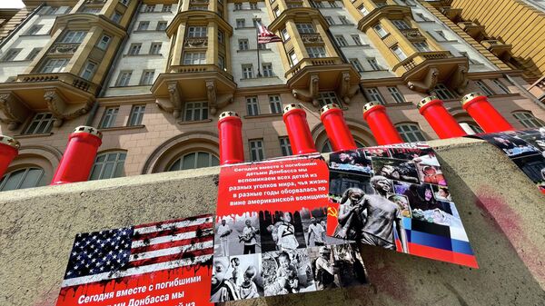 Свечи и фотоколлажи в память о детях Донбасса, установленные участниками акции у посольства США в Москве
