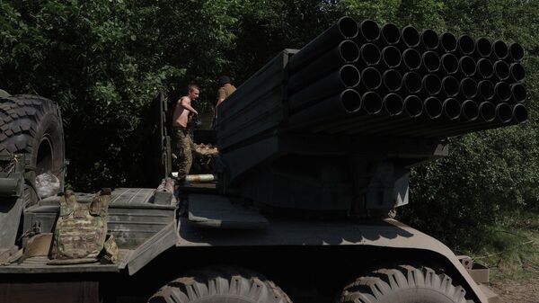 Украинский артиллерист заряжает реактивную систему залпового огня БМ-21 Град