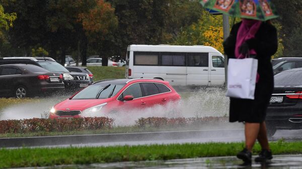 Женщина с зонтом во время дождя на одной из улиц в Москве