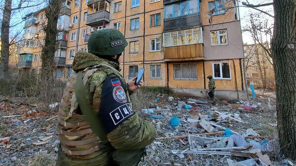 Сотрудники СЦКК у жилого дома, поврежденного в результате обстрела Донецка со стороны ВСУ