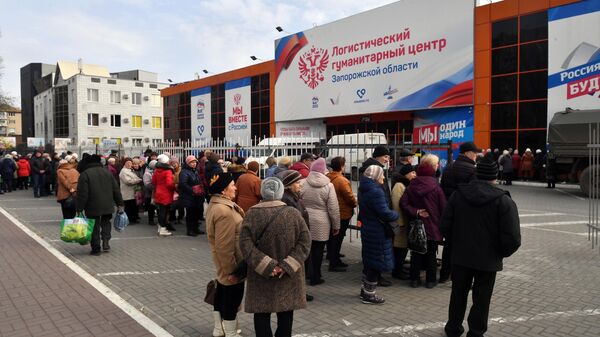 Жители Запорожской области стоят в очереди за продовольственными наборами в логистическом гуманитарном центре в Мелитополе