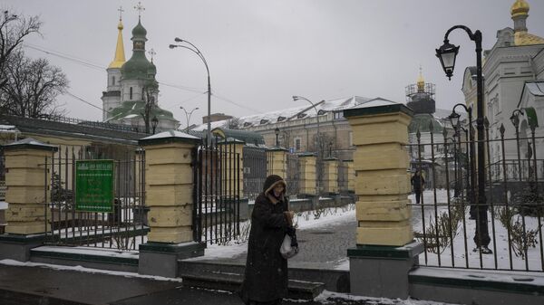 Женщина проходит мимо Киево-Печерской лавры в Киеве