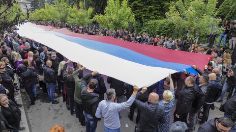 Люди с флагом Сербии перед мэрией в городе Звечан на севере Косово