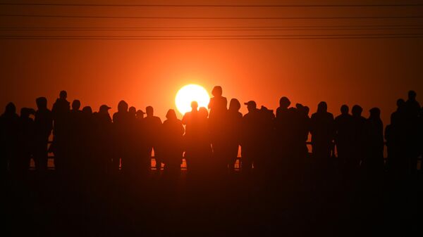 Люди стоят во время заката