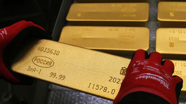 Сотрудник помещает на тележку готовый маркированный слиток золота высшей пробы 99,99 процента чистоты на заводе цветных металлов. Архивное фото