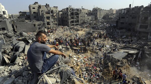 Мужчина сидит на обломка на севере сектора Газа
