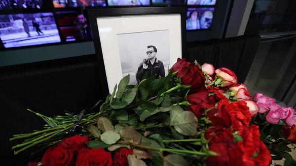 Цветы у портрета корреспондента телеканала Россия 24 Бориса Максудова на входе в здание ВГТРК
