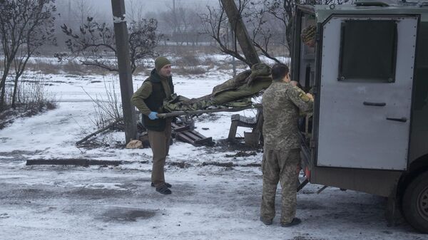 Украинские военнослужащие переносят носилки с раненым в Донецкой области