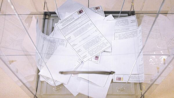 Бюллетени в урне для голосования на выборах президента России на одном из избирательных участков в Новосибирске