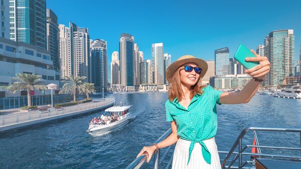 Девушка делает селфи во время круиза в Дубае