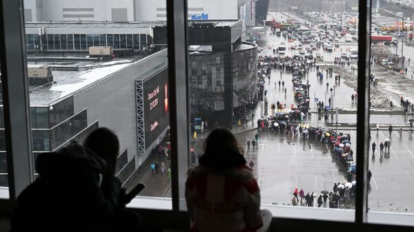 Люди стоят в очереди к стихийному мемориалу возле подмосковного Крокус Сити Холла в память о жертвах теракта