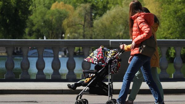 Девушки с коляской прогуливаются в Парке Горького в Москве