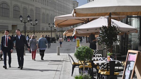 Прохожие у летней веранды на Никольской улице в Москве