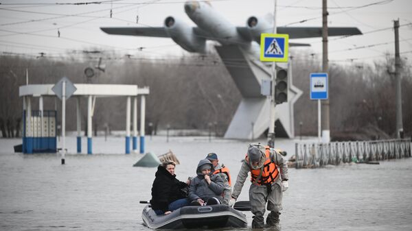 Сотрудники МЧС РФ эвакуируют жителей города в ходе ликвидации последствий прорыва дамбы в Орске