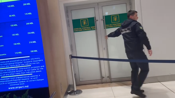 Служащий выходит из дверей зоны таможни в аэропорту Кишинева. 22 апреля 2024