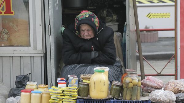 Пожилая женщина торгует на улице в Киеве