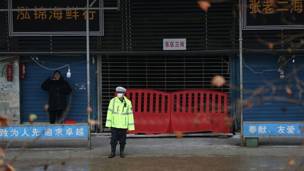Сотрудник полиции у закрытого рынка морепродуктов в Ухане, КНР