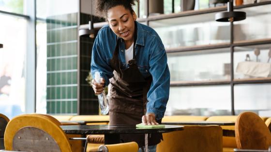 Waitress cleaning table in cafe