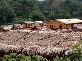 Vue d’une localité tropicale de Gnanti, dans la commune de Bilolo, avec des toitures de chaume et un bâtiment intitulé “DYNAMES DE YANTE”, nichée dans une vallée verdoyante