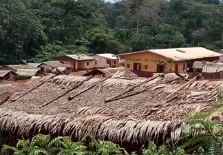 Vue d’une localité tropicale de Gnanti, dans la commune de Bilolo, avec des toitures de chaume et un bâtiment intitulé “DYNAMES DE YANTE”, nichée dans une vallée verdoyante